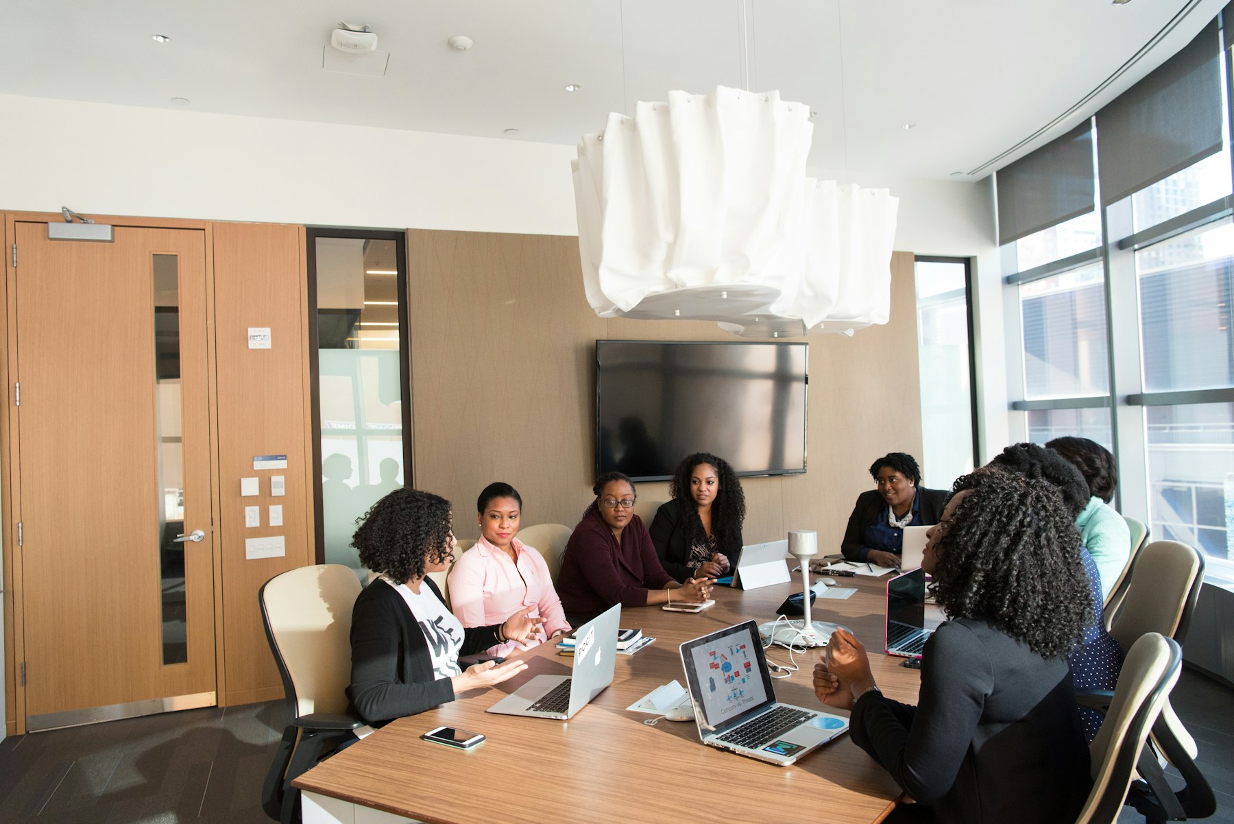 A leadership team collaborating around a laptop in a bright, modern office