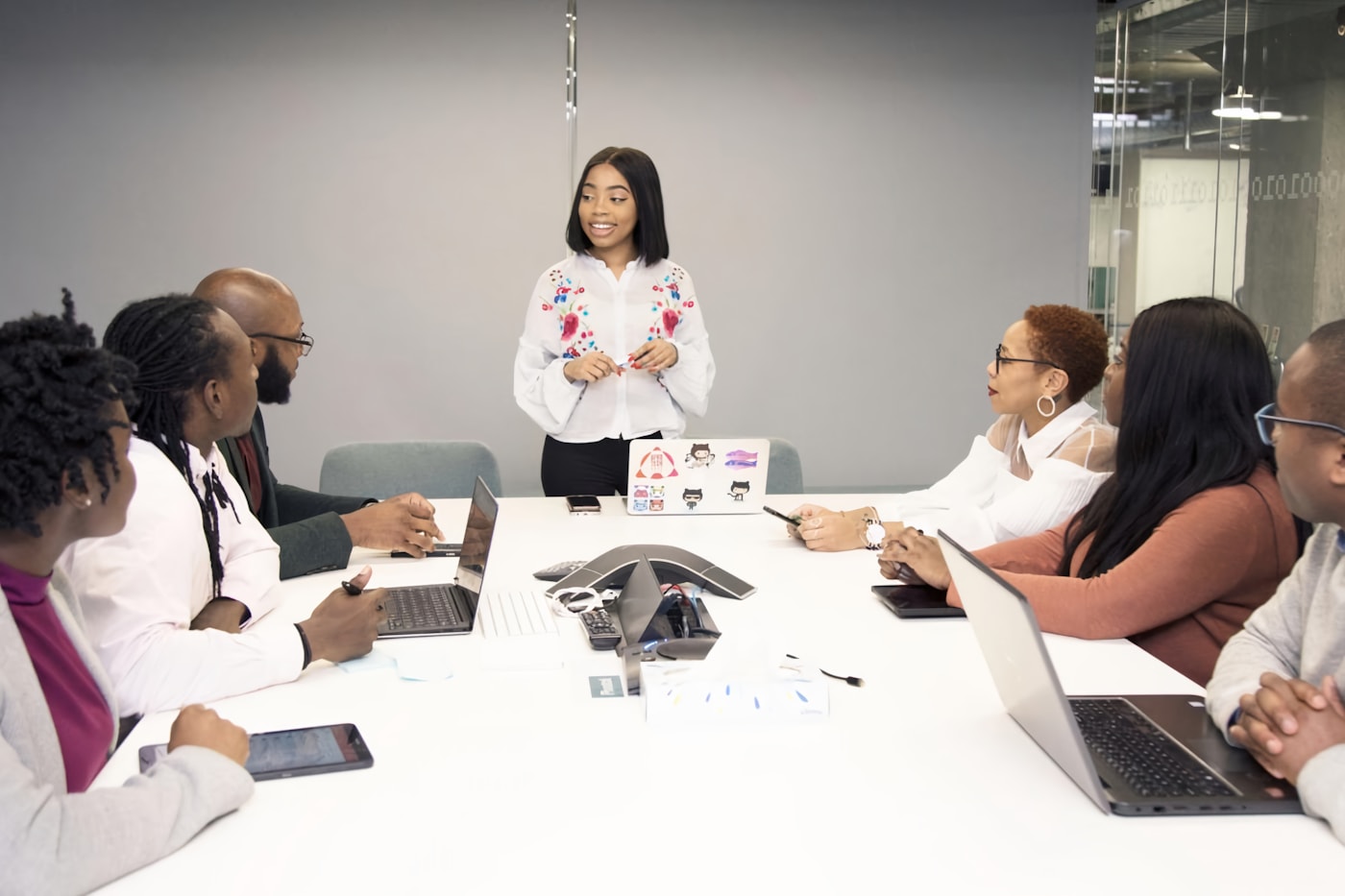 A facilitator presenting a solution to a seated team in a bright office